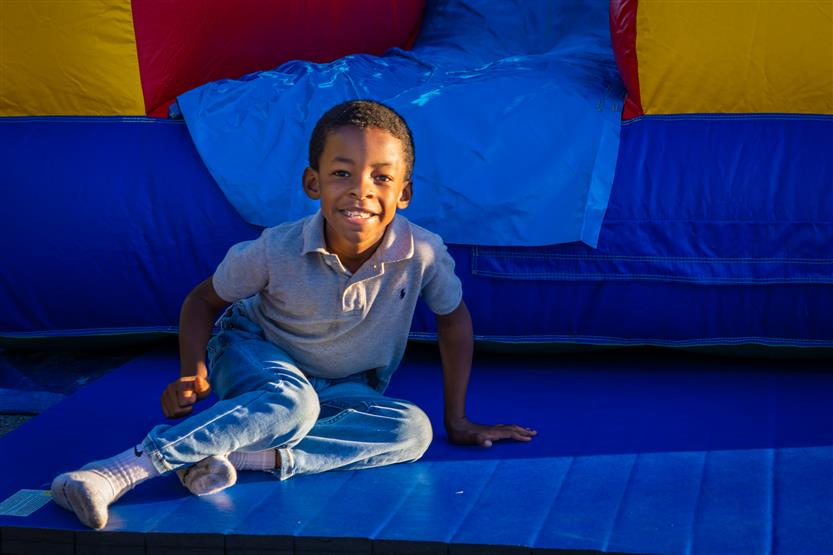 A boy smiles at the end of a slide